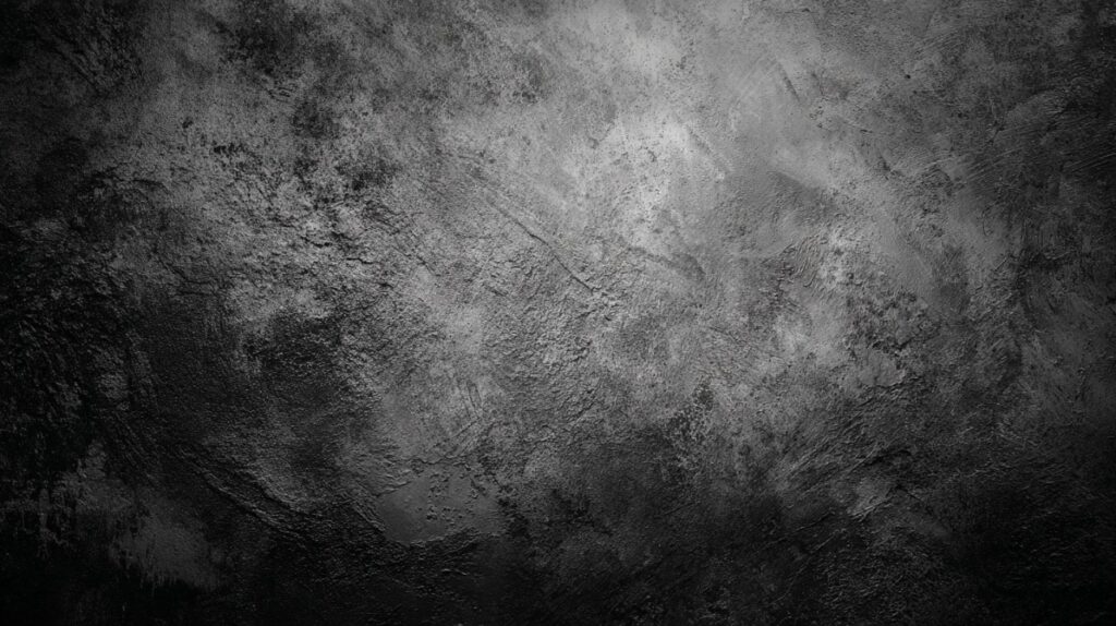 Close-up of a dark black rough textured surface with gray tones creating a dramatic and moody background.