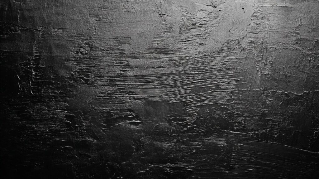 Close-up of a black background with rough texture and dark gray tones, creating a dramatic and textured visual effect.
