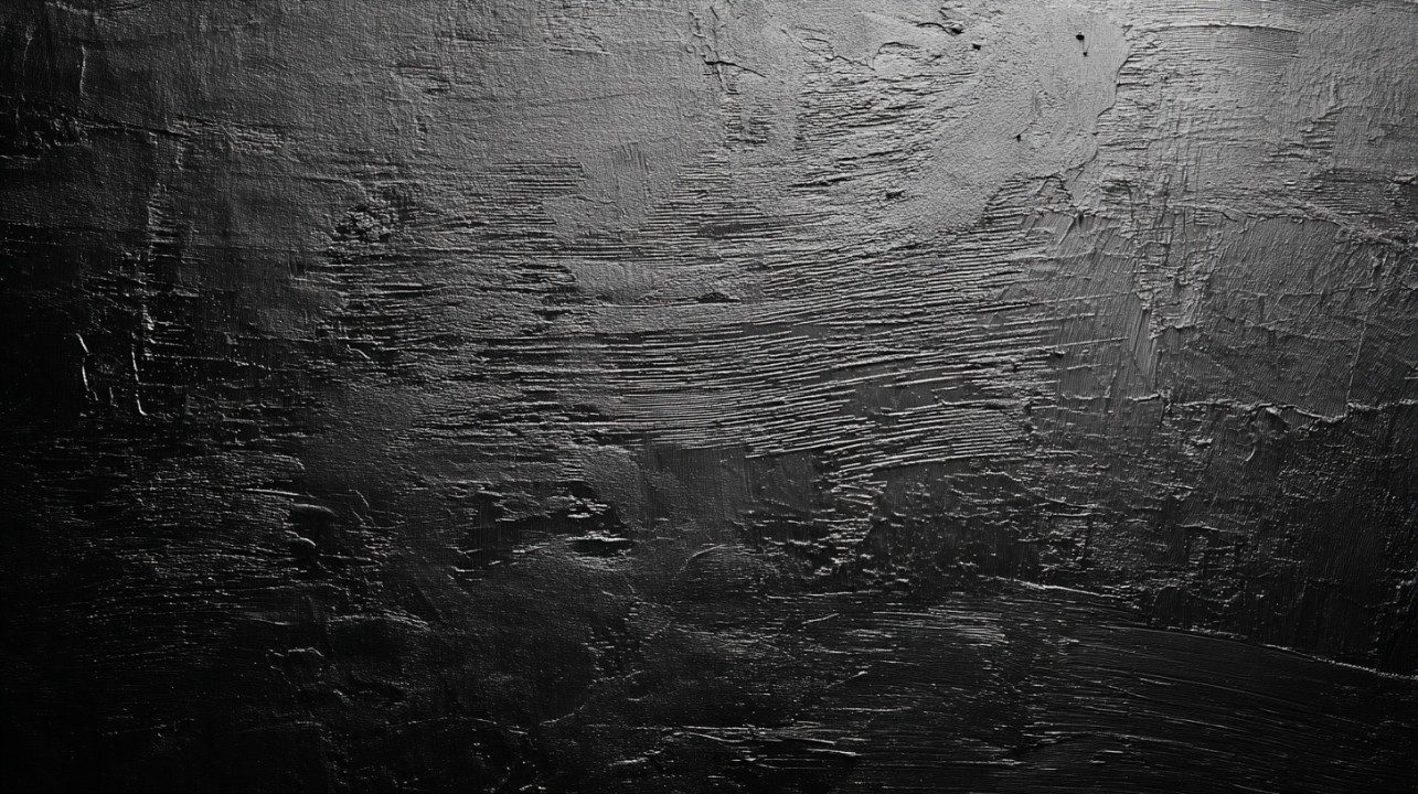 Close-up of a black background with rough texture and dark gray tones, creating a dramatic and textured visual effect.