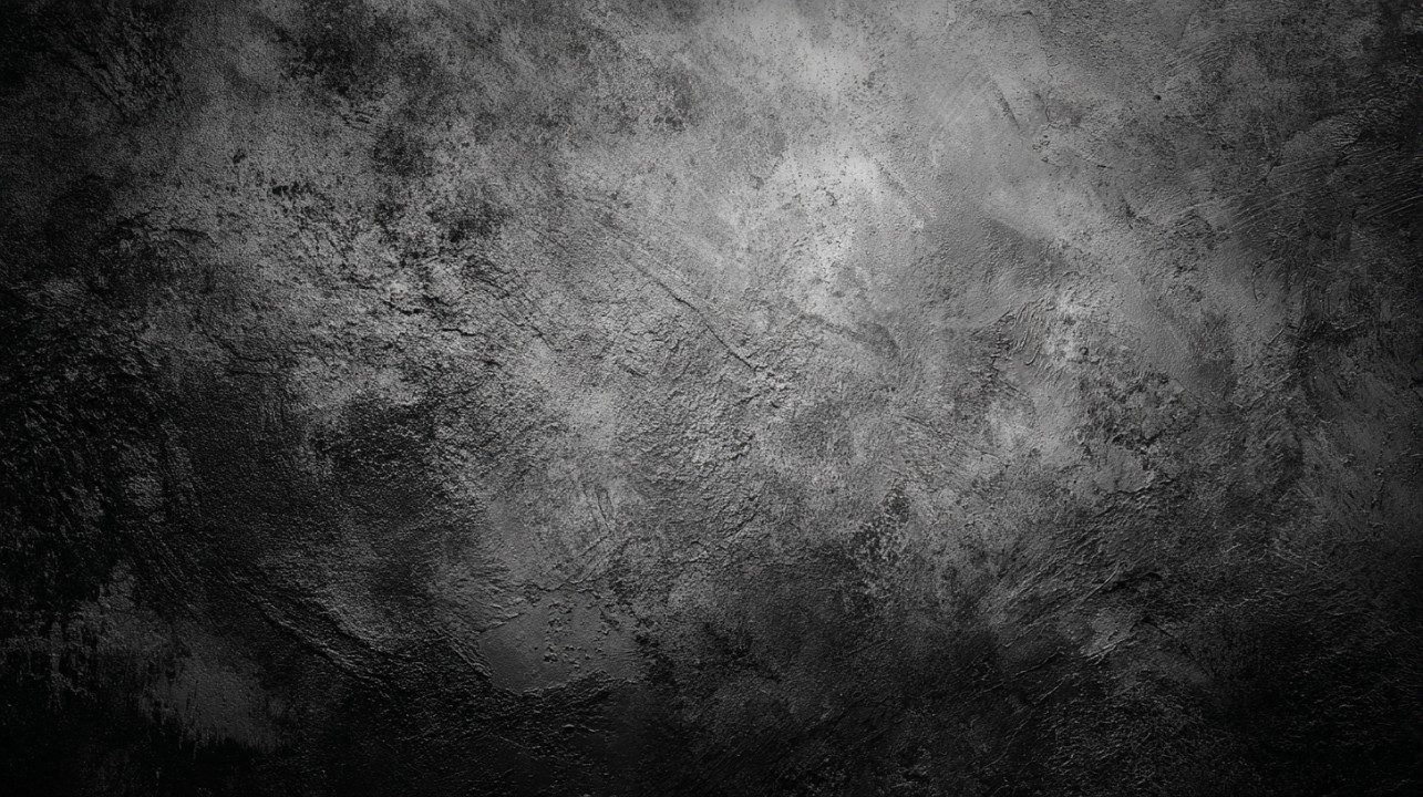 Close-up of a dark black rough textured surface with gray tones creating a dramatic and moody background.