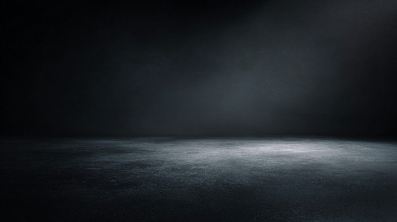 Dark photo studio background with soft ambient lighting and a textured floor creating a dramatic and professional setting.