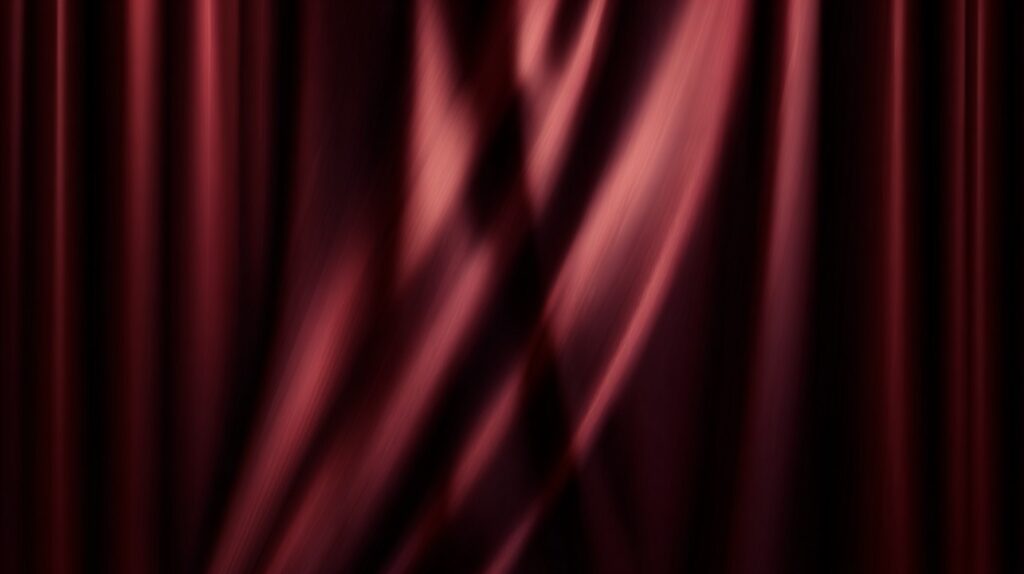 Deep burgundy curtain with soft lighting and dramatic folds, suitable for elegant stage or branding visuals.