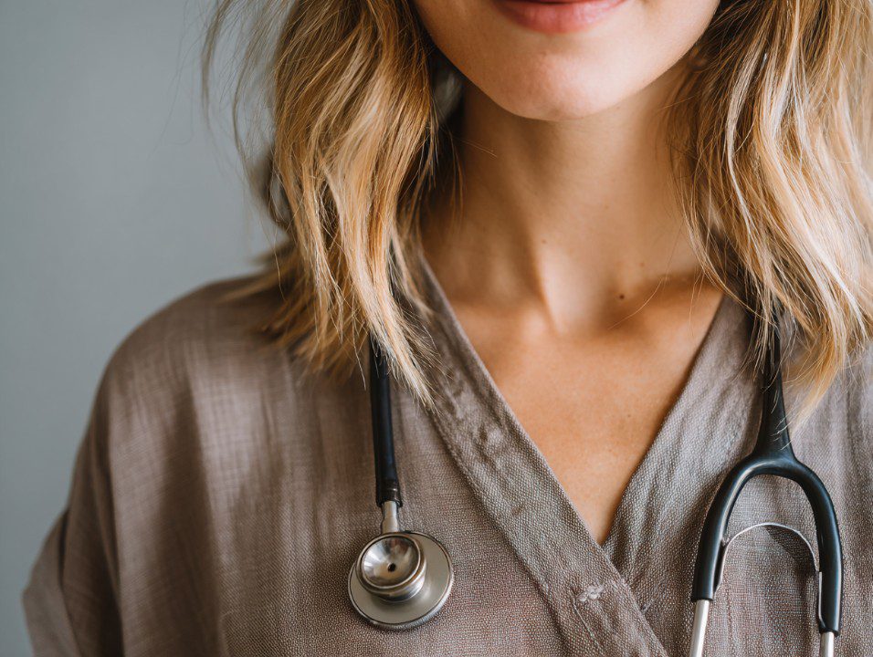 Close-up of a female healthcare professional with a stethoscope around her neck, symbolizing medical care and patient support.