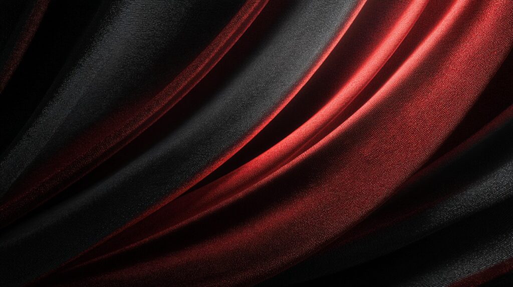 Elegant flowing black and red fabric folds with rich texture and dramatic lighting.
