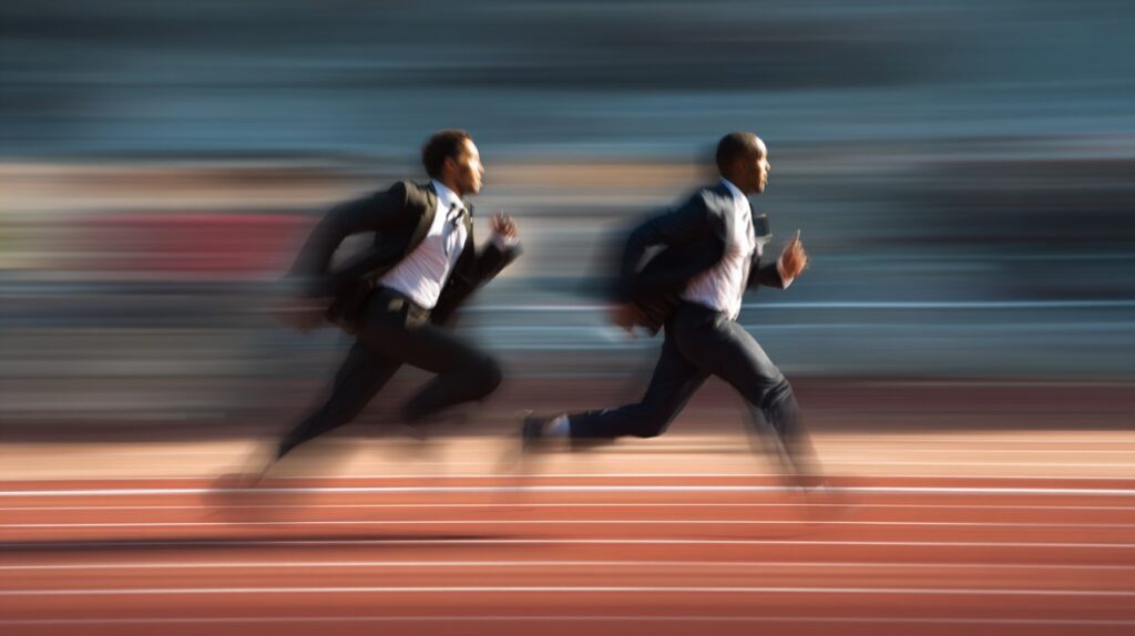 Two businessmen in suits sprinting on a running track, symbolizing corporate speed, competition, and business urgency.