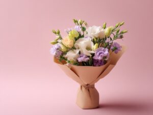 Pastel-colored lisianthus bouquet wrapped in paper, displayed against a soft pink background—ideal for romantic and celebratory visuals.