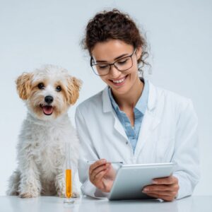 Female veterinarian smiles while reviewing data on a tablet next to a happy dog and a test sample in a clean laboratory environment.