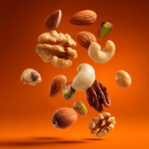 Assorted nuts including almonds, walnuts, pistachios, and cashews floating against a vibrant orange background, showcasing healthy snacking.
