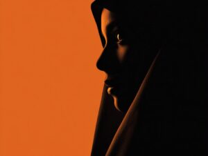 Side-profile silhouette of a person in shadow against a warm orange background, evoking emotion and mystery through artistic lighting.