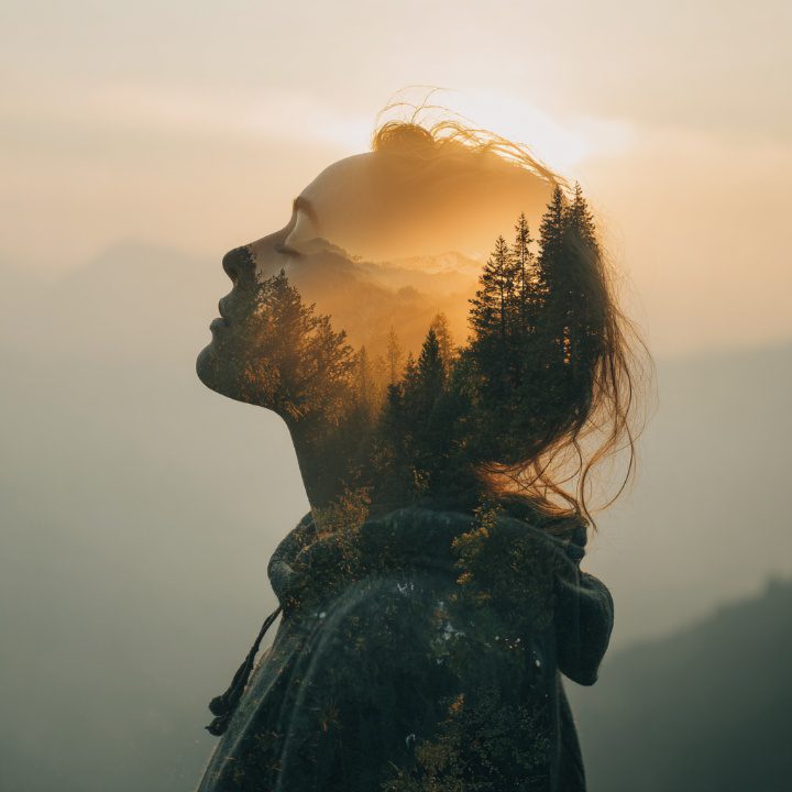 Artistic double exposure of a woman’s profile merged with a forest at sunset, evoking serenity and mindfulness.