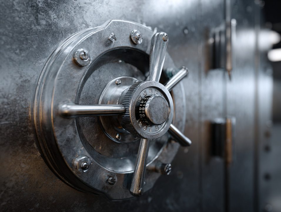 Detailed view of a solid steel bank vault door with a classic combination lock and secure locking bars, symbolizing financial security and protection.